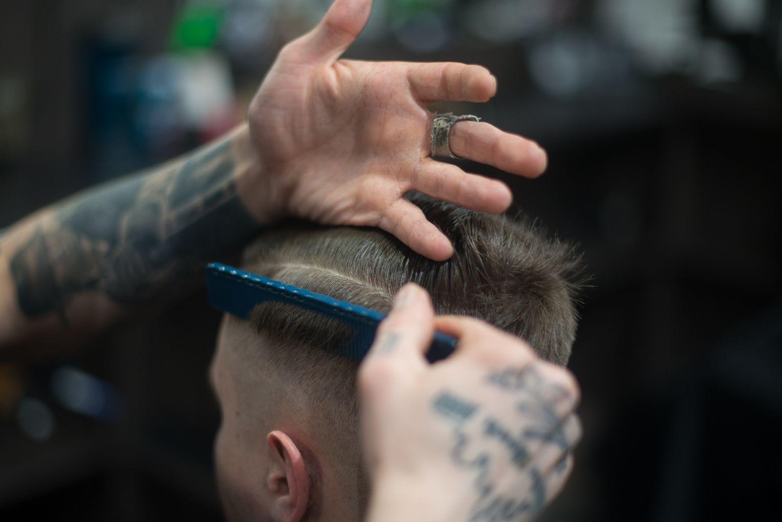Close-up of a comb lifting hair above a freshly cut high skin fade